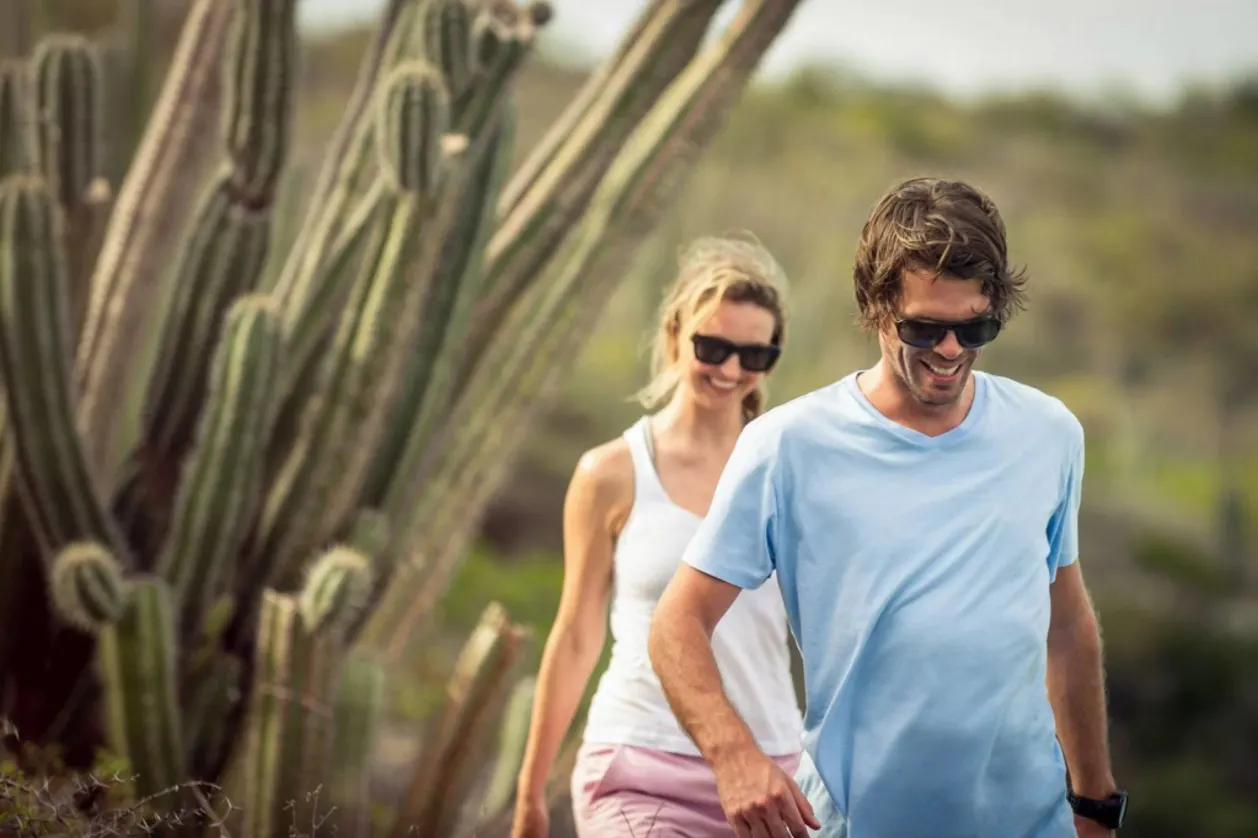 couple hiking amidst cactus at Canyon Ranch Tucson wellness retreat in U.S.
